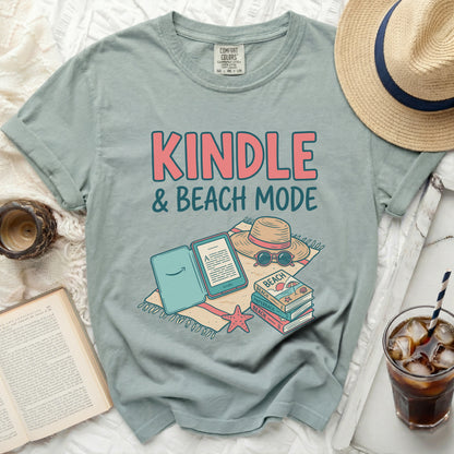 T-shirt with "KINDLE & BEACH MODE" text, a Kindle, and beach-themed accessories.