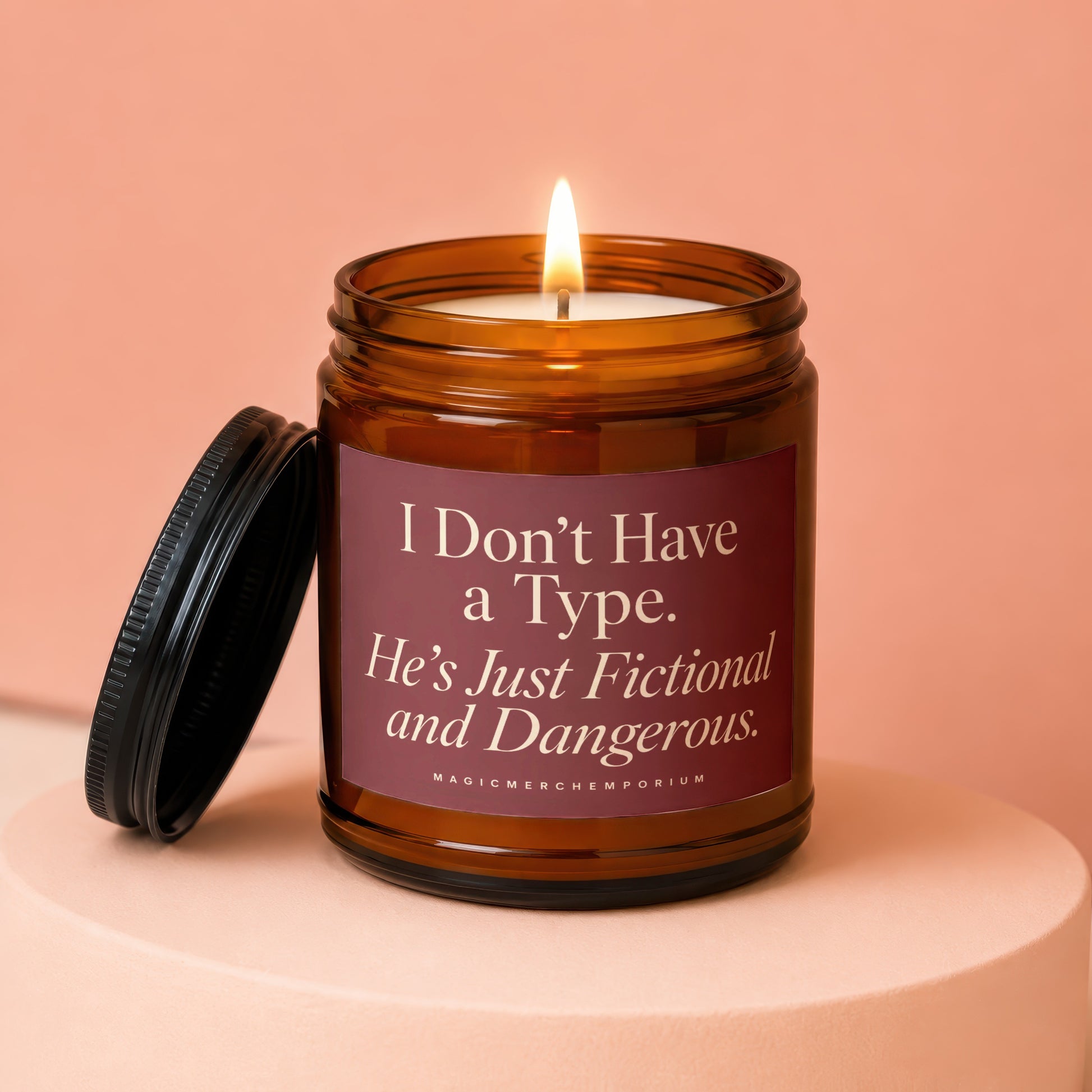 Amber jar candle with burning wick and label that reads "I Don't Have a Type. He's Just Fictional and Dangerous."