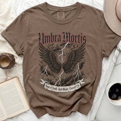 Brown t-shirt with "Umbra Mortis Angel of Death" text and black wings.