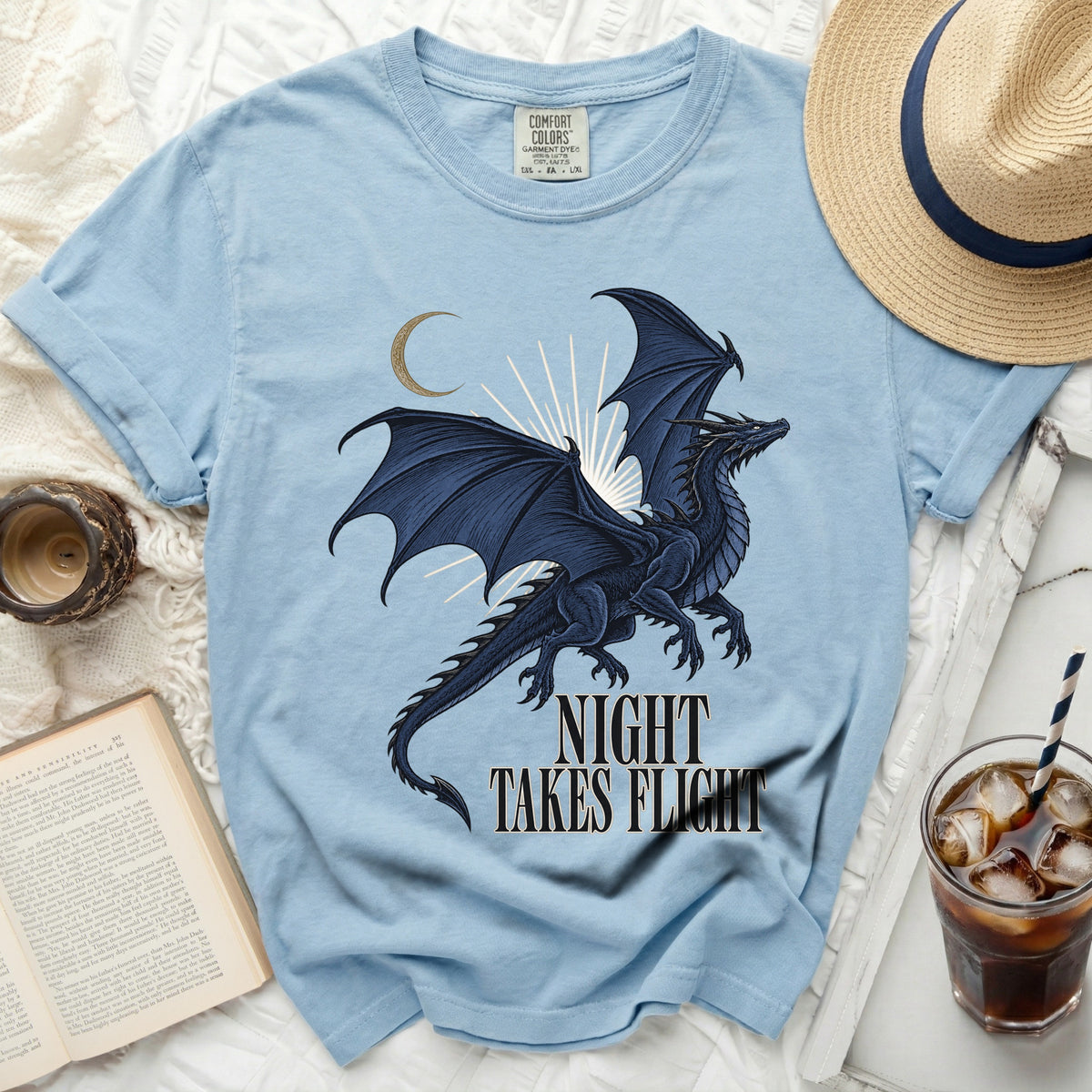 Light blue t-shirt with a dark blue dragon graphic and text "NIGHT TAKES FLIGHT".