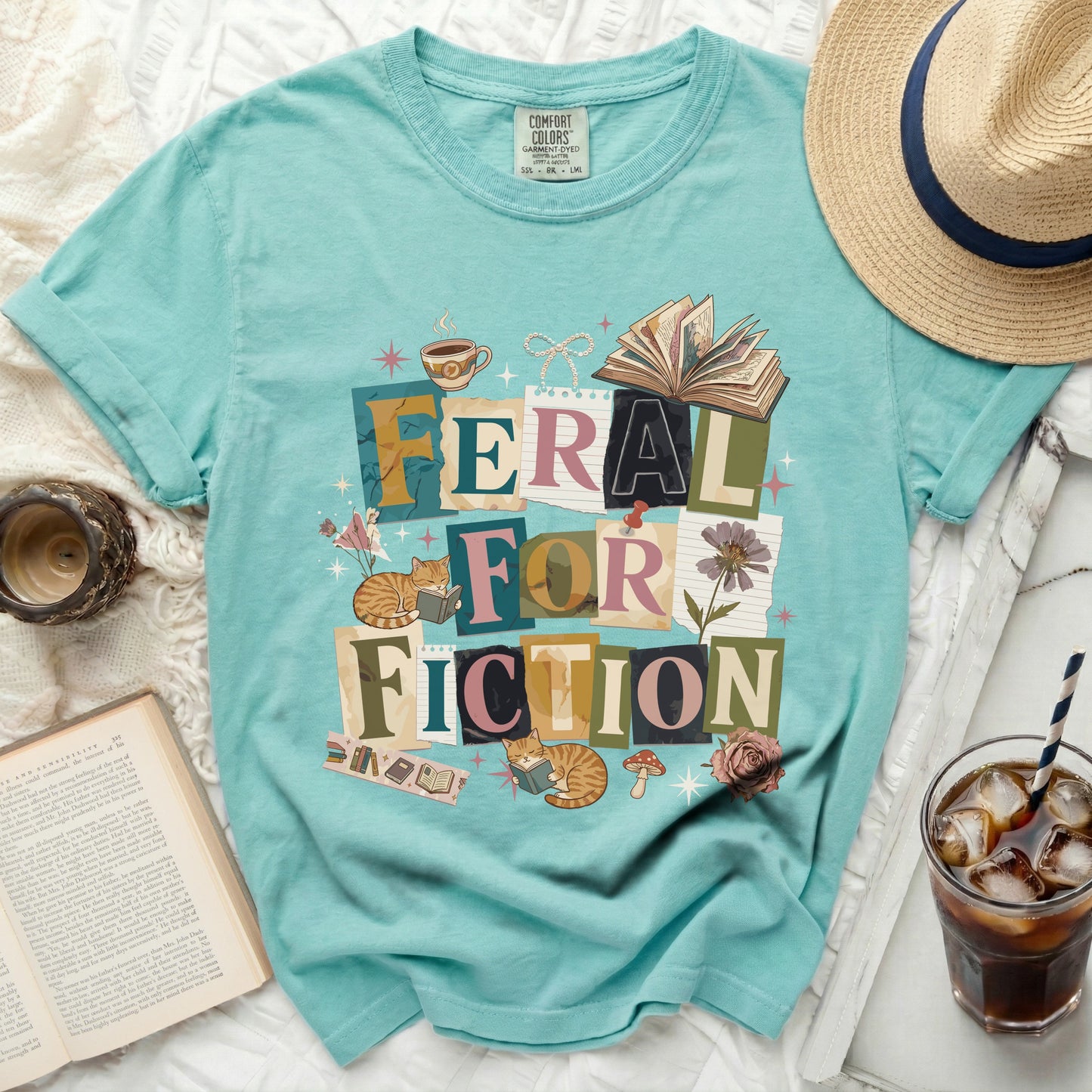 T-shirt with "Feral for Fiction" text, books, cats, and coffee cup graphic.