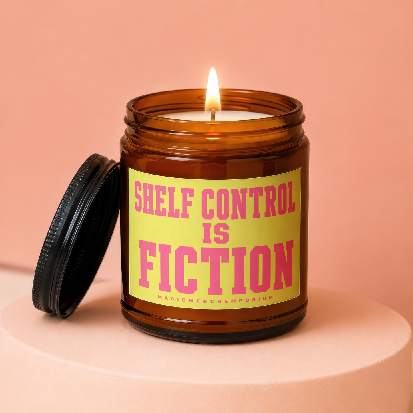 Amber jar candle with lit wick, reads "Shelf Control is Fiction" and "MagicMerchEmporium".
