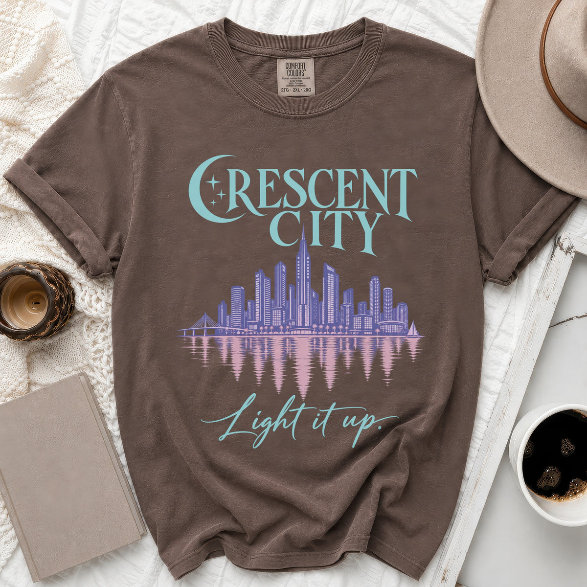 Brown t-shirt with "Crescent City" and skyline graphic, "Light it up" text.