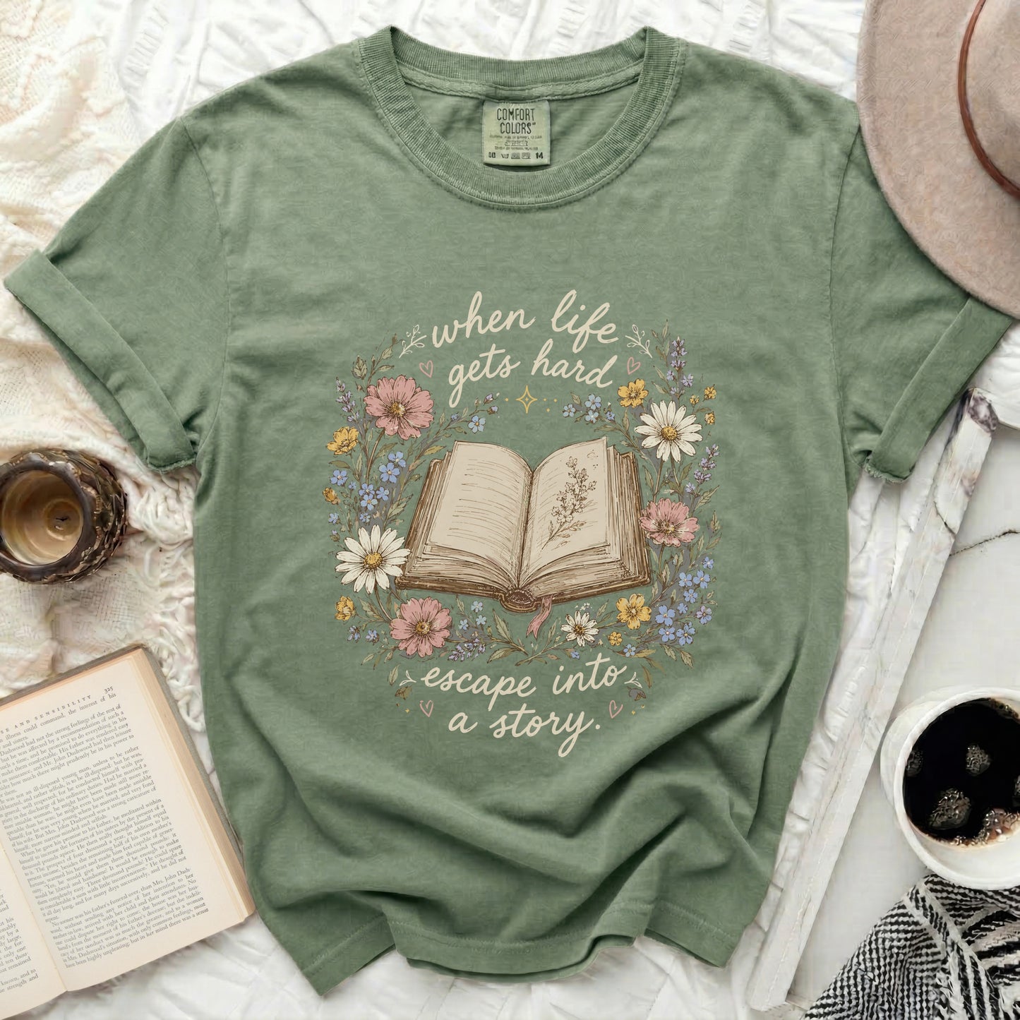 Green t-shirt with floral wreath around open book and text.