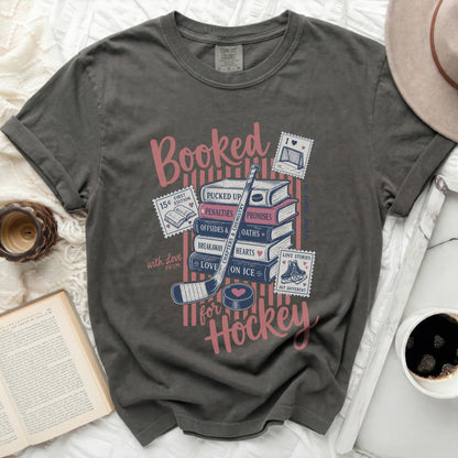 Gray t-shirt with "Booked for Hockey" in pink and blue text.