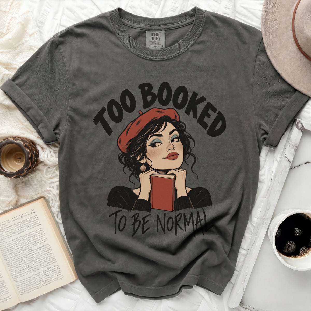 Dark grey t-shirt with "Too Booked To Be Normal" text and illustration.