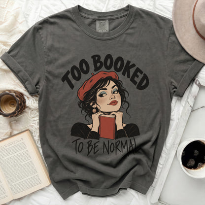 Dark grey t-shirt with "Too Booked To Be Normal" text and illustration.