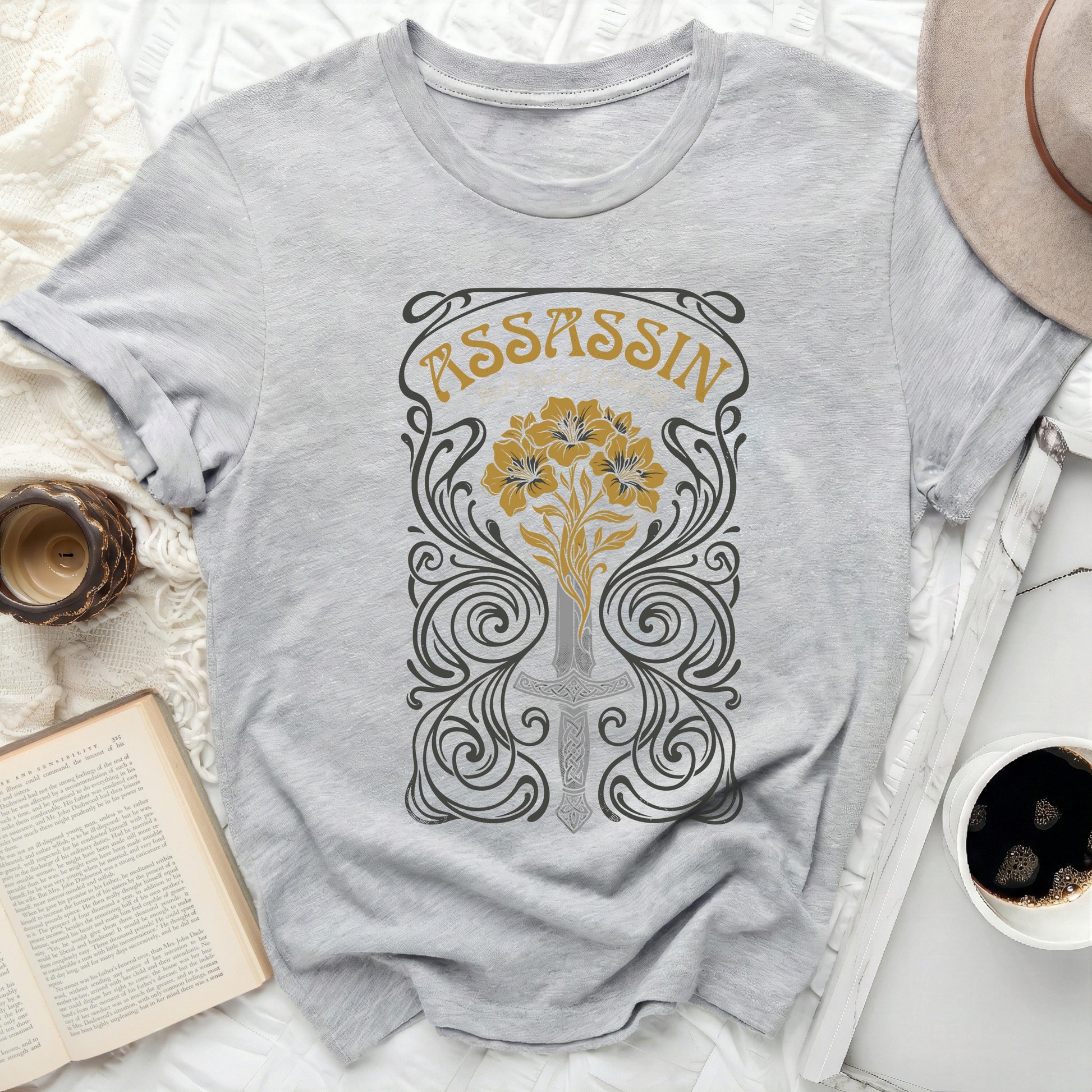 Grey t-shirt with ornate "ASSASSIN" text and floral sword design.
