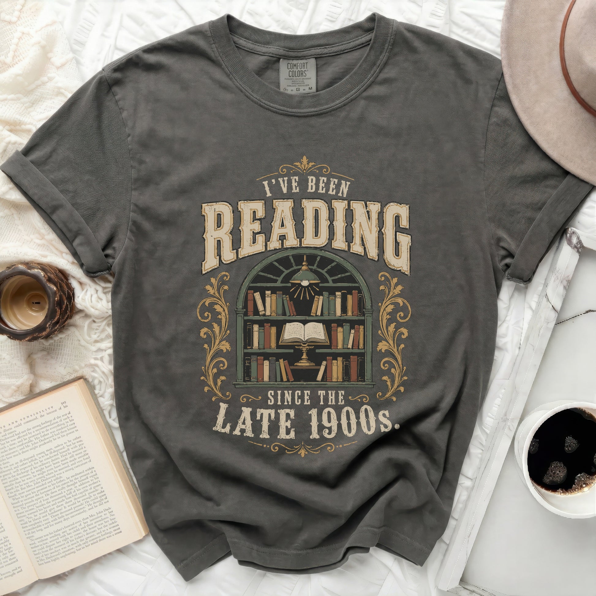 Graphic tee with "I've Been Reading Since the Late 1900s" and bookshelf design.