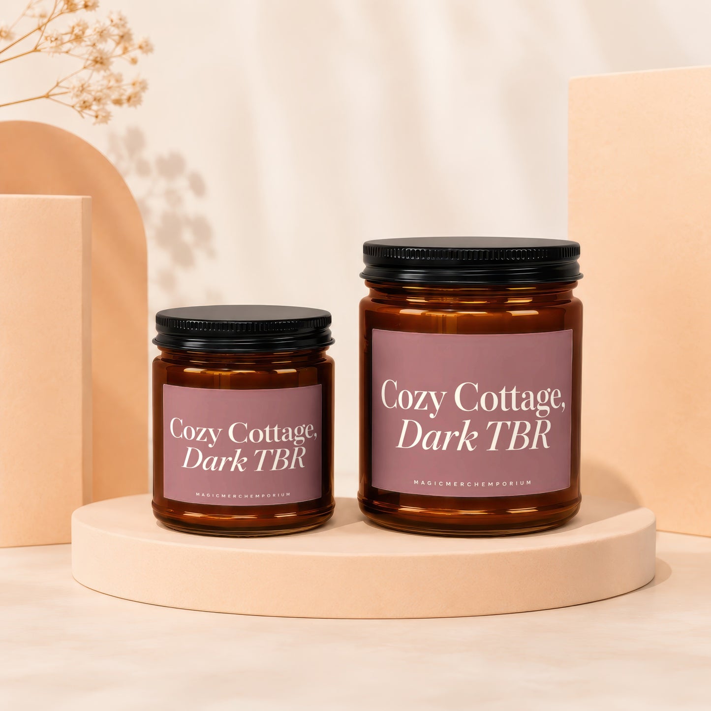 Two amber glass candles with "Cozy Cottage, Dark TBR" text lie on pedestals.