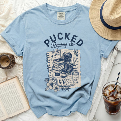 Light blue t-shirt with "Pucked Reading List" hockey and book graphic.