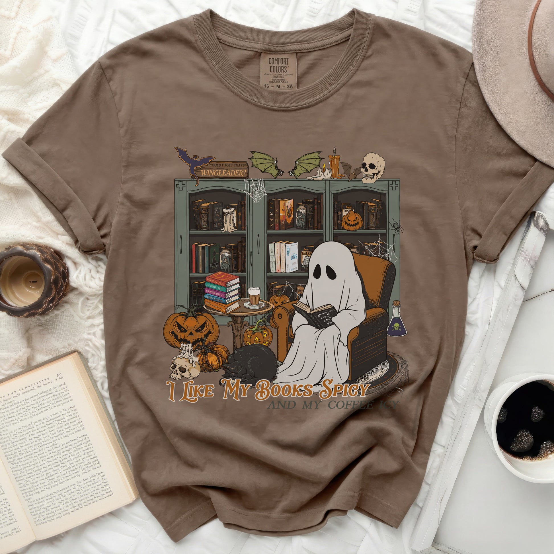 Ghost reading book with pumpkins and black cat, "I like my books spicy and my coffee" text.