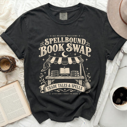 Black t-shirt with "Spellbound Book Swap" and "Trade Tales & Spells" graphics.