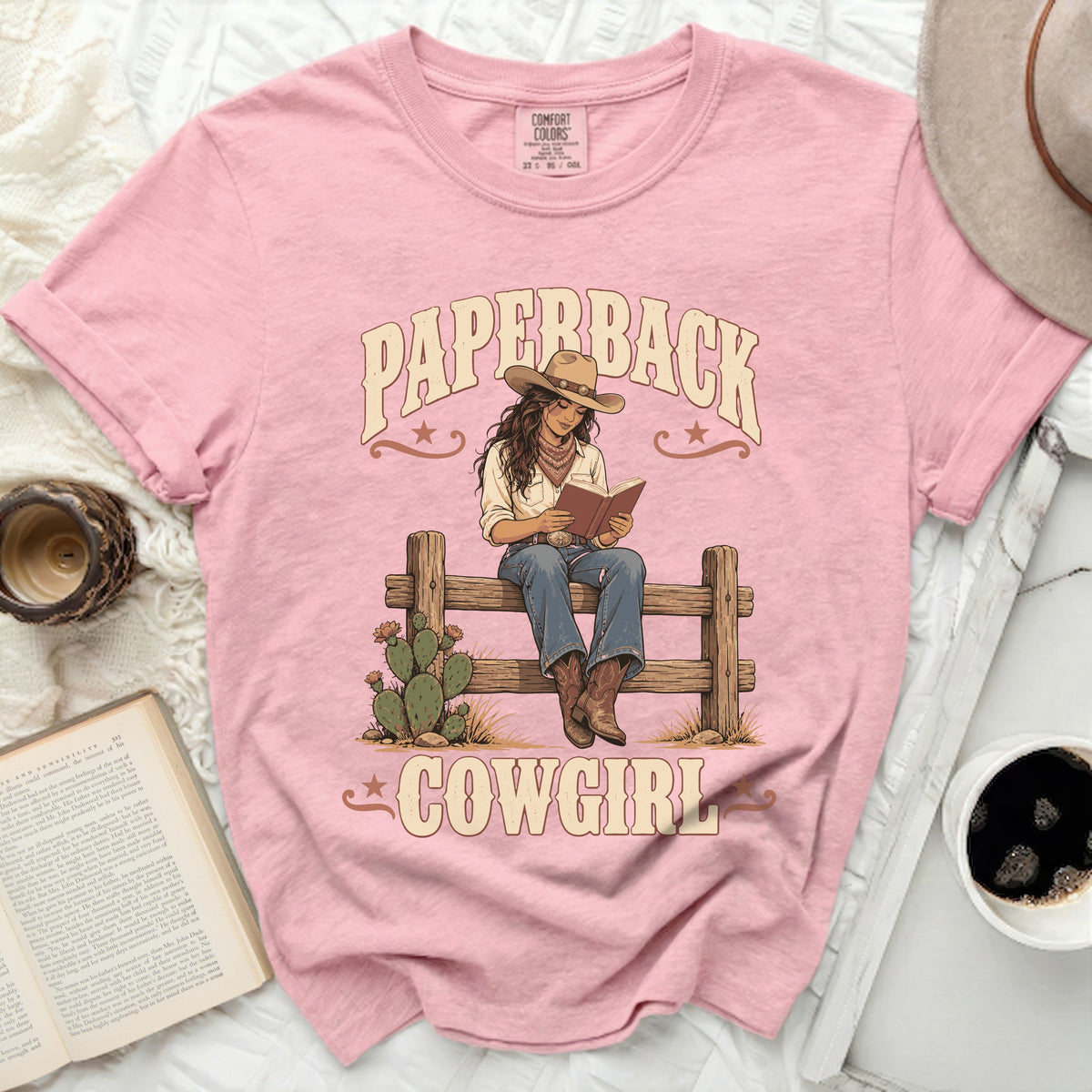 Graphic tee with "Paperback Cowgirl" text and illustration of cowgirl reading.