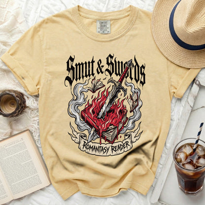 Yellow t-shirt with "Smut & Swords Romantasy Reader" graphic.