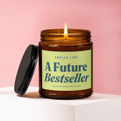 Amber candle with lit wick, label reads "A Future Bestseller" and "MAGICMERCHEPORIUM".