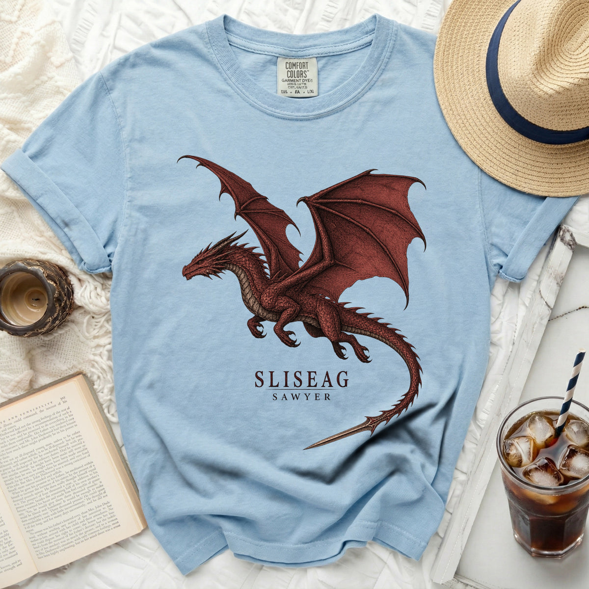 Light blue t-shirt with a red dragon graphic and text "SLISEAG SAWYER".