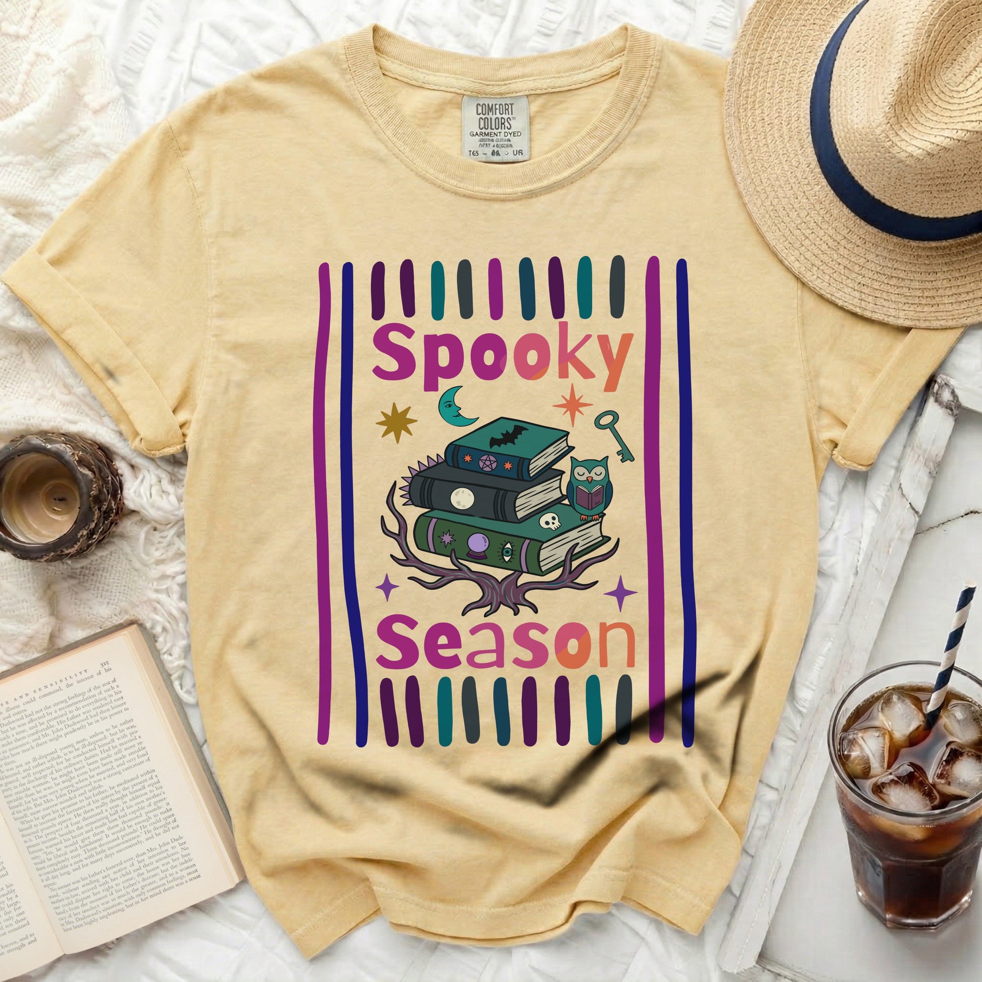 Yellow t-shirt with "Spooky Season" graphic of books, owl, and Halloween icons.