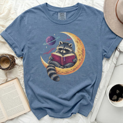 Raccoon sitting on a crescent moon reading a book, with a planet in the background.