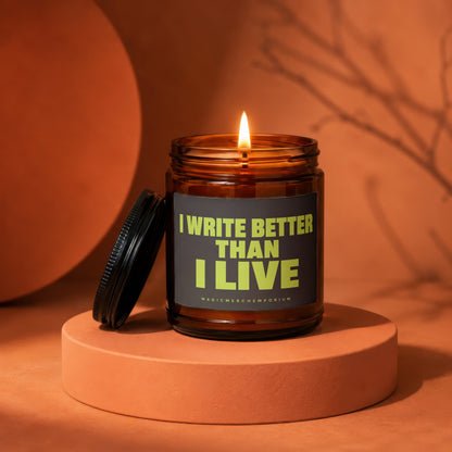 Amber jar candle with lit wick, dark label reads "I WRITE BETTER THAN I LIVE".