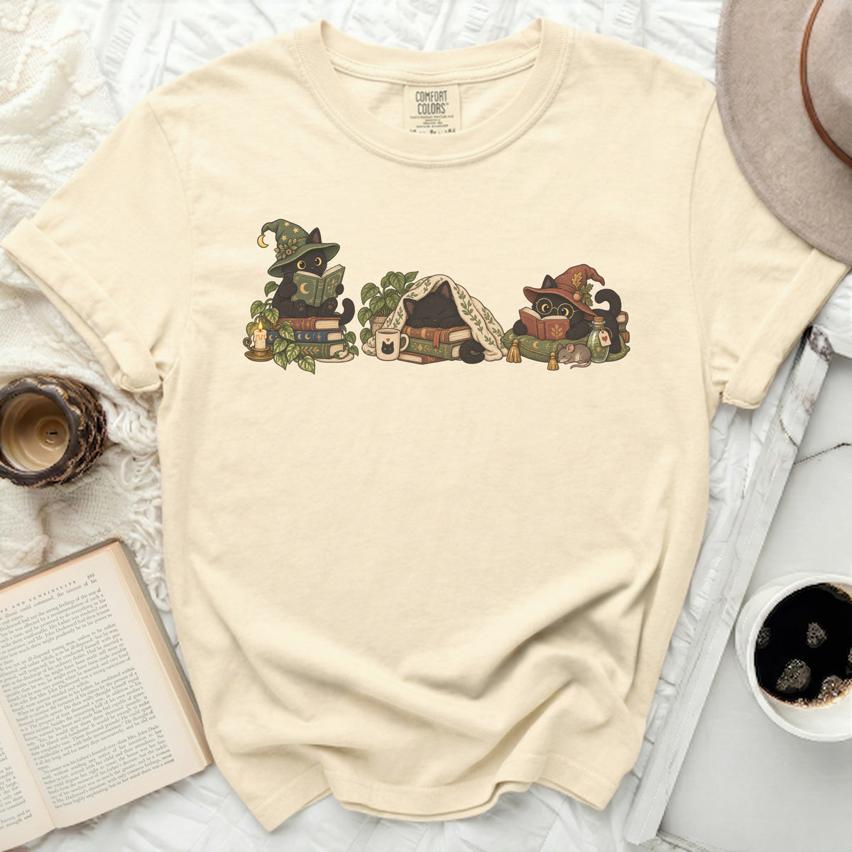 Three black cats wearing wizard hats reading books, one sleeping.