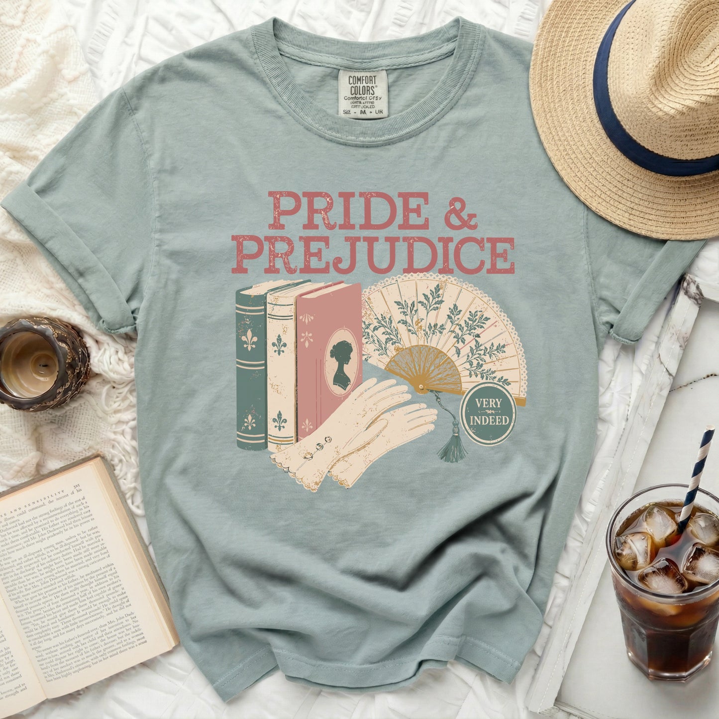 T-shirt with "Pride & Prejudice" text, books, fan, and gloves graphic.