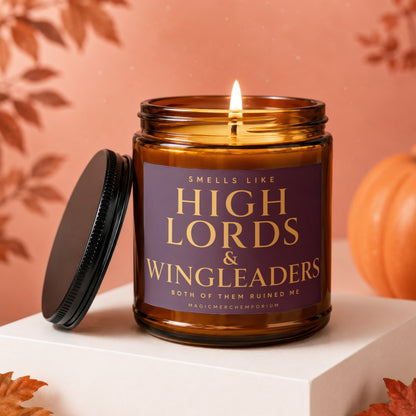 Amber candle with a lit wick and a purple label reading "Smells Like High Lords & Wingleaders. Both of Them Ruined Me."