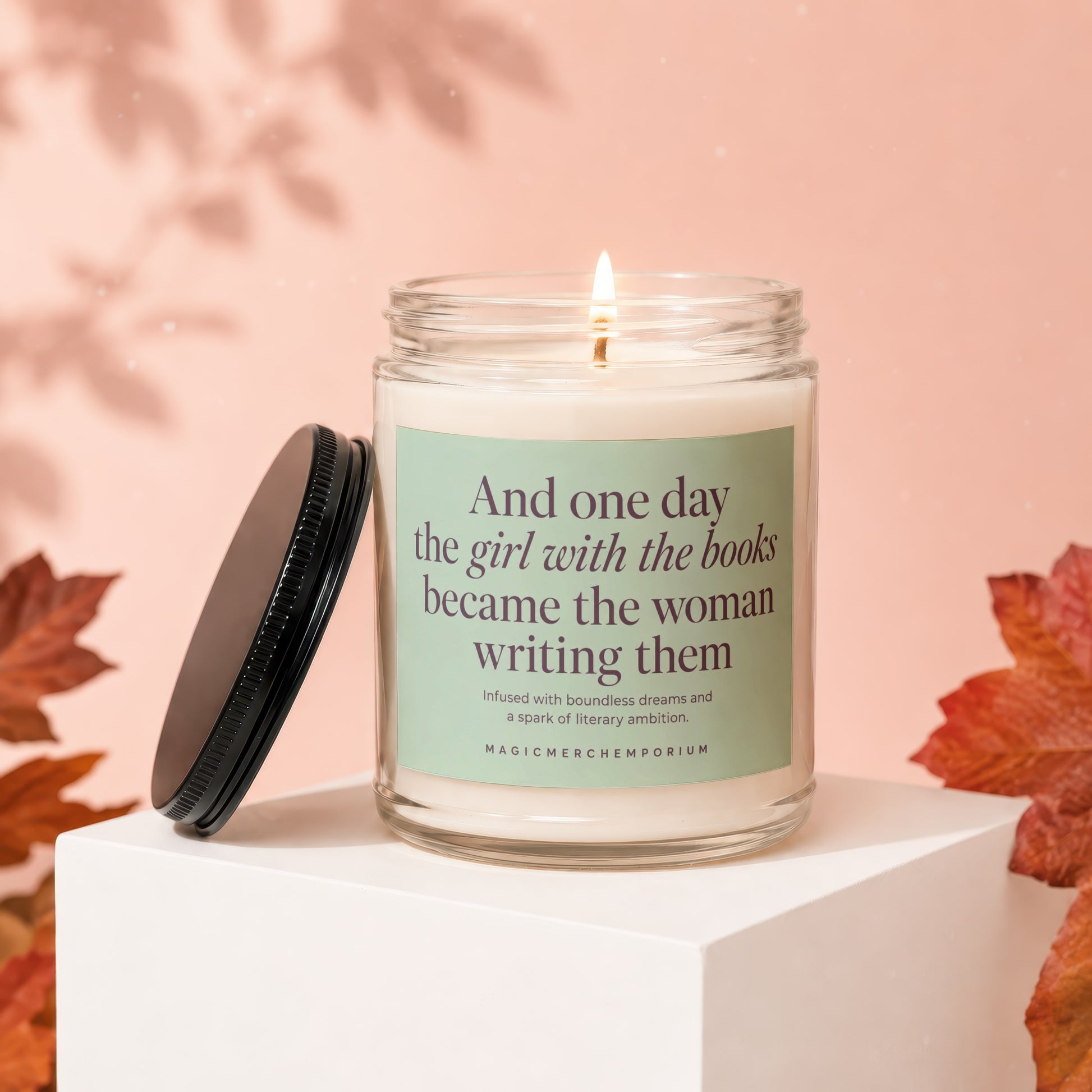 Candle with text: "And one day the girl with the books became the woman writing them."