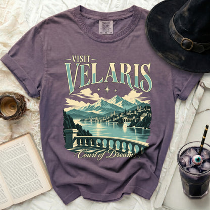 Purple t-shirt with "Visit Velaris Court of Dream" text and fantasy city landscape.