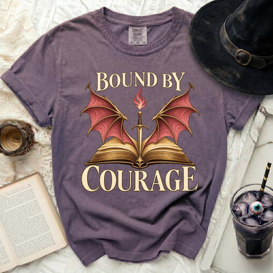Purple t-shirt with dragon wings, sword, and text "BOUND BY COURAGE".