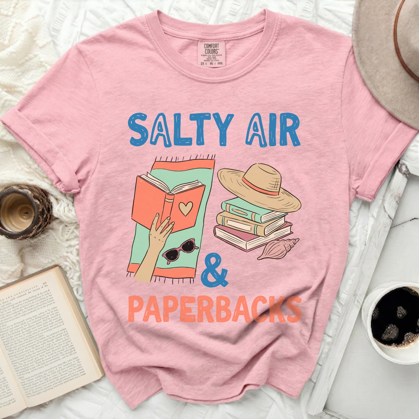 Pink t-shirt with "Salty Air & Paperbacks" text and book graphic.