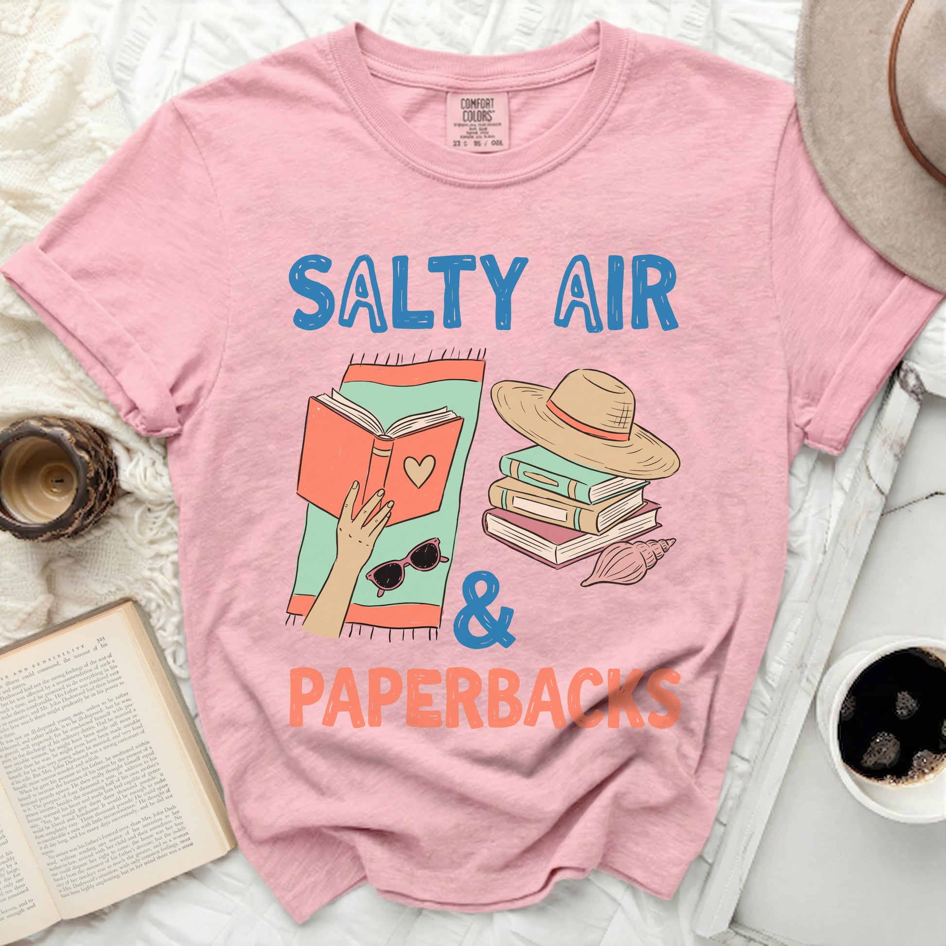 Pink t-shirt with "Salty Air & Paperbacks" text and book graphic.