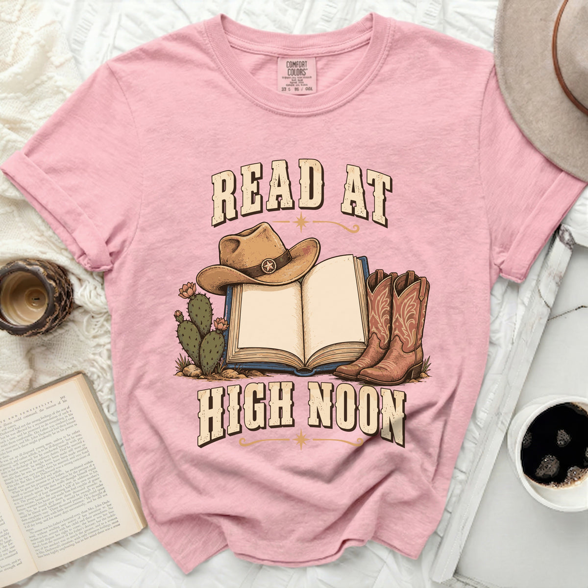 Pink t-shirt with "Read at High Noon" text, cowboy hat, boots, and cactus graphic.