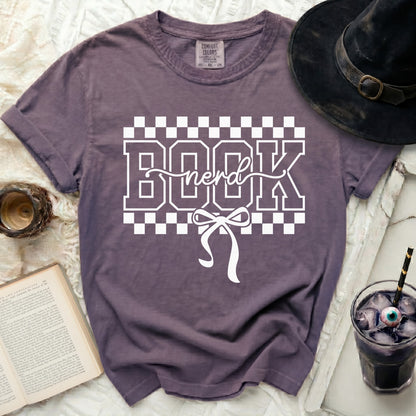 Purple t-shirt with white "BOOK nerd" text and bow graphic.