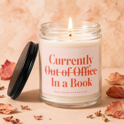 Candle labeled "Currently Out of Office In a Book" with lit wick.