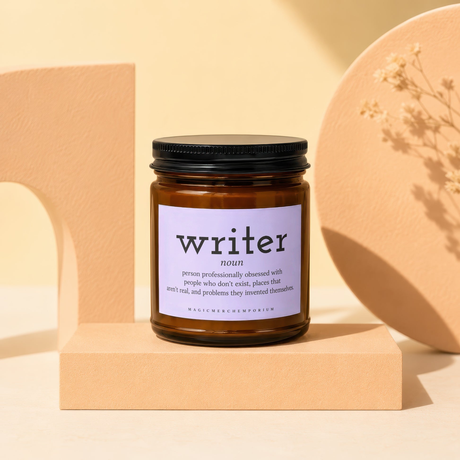 Brown glass candle with "writer noun" definition label and "MAGICMERCHEMPORIUM" text.