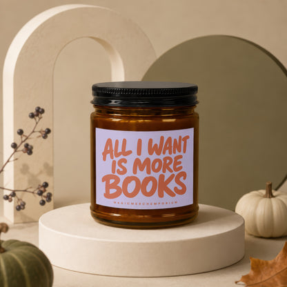 Amber glass candle with a black lid, featuring a purple label with orange text stating "ALL I WANT IS MORE BOOKS".