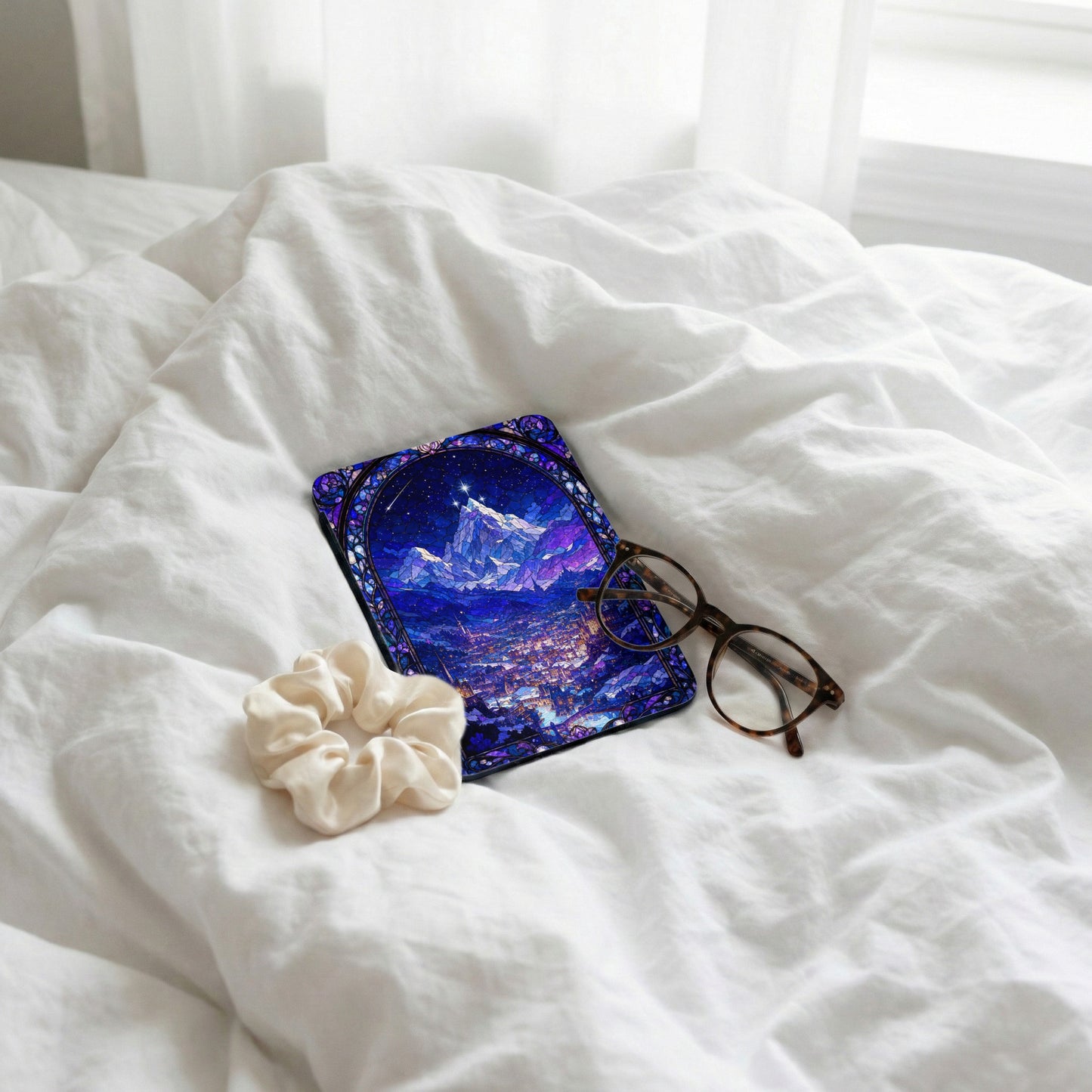Phone case with stained glass mountain and city art, glasses, scrunchie on white sheets