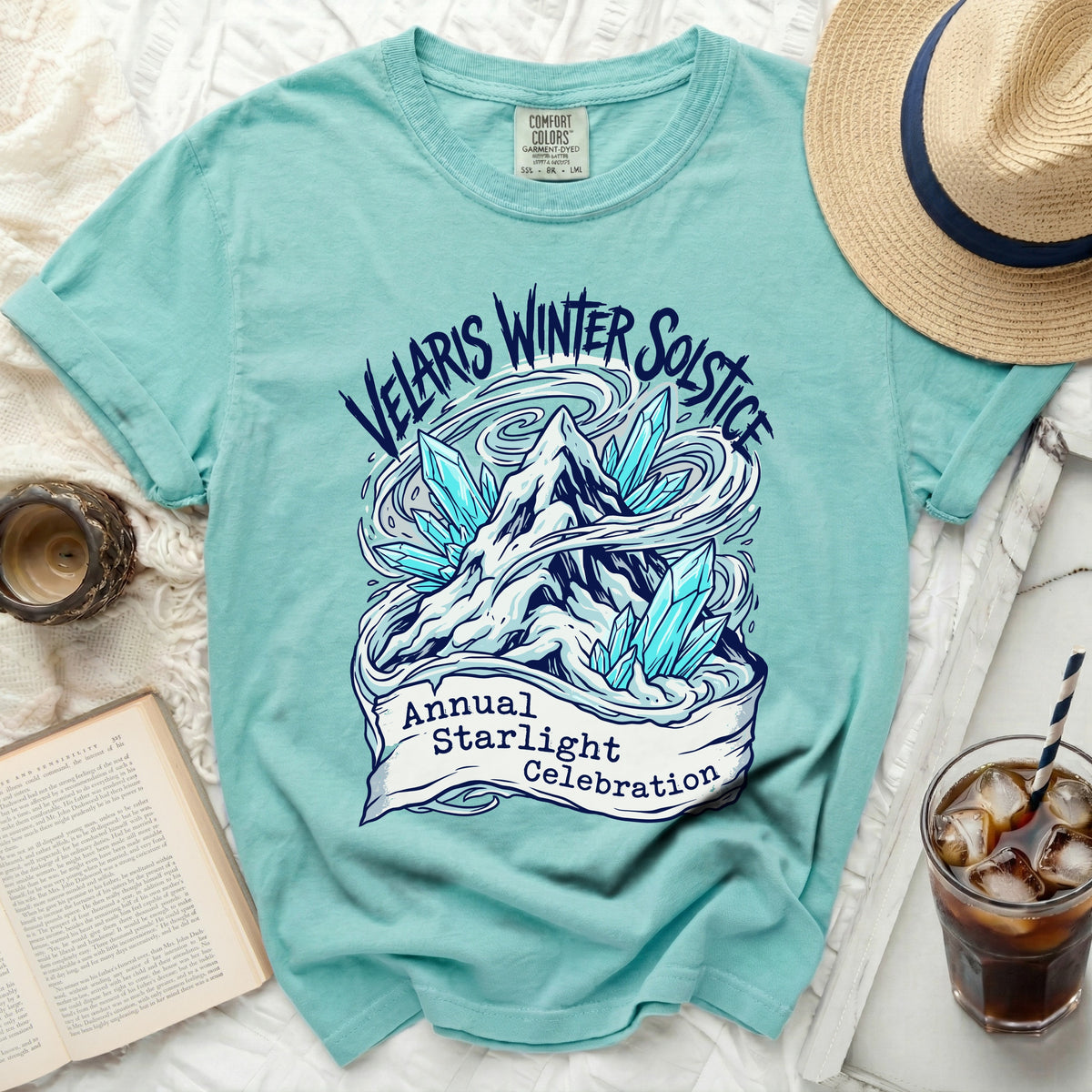 Teal t-shirt with "Velaris Winter Solstice Annual Starlight Celebration" text and mountain crystal graphic.