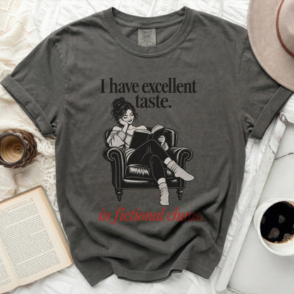 Dark grey t-shirt with illustration of woman reading and text "I have excellent taste. in fictional chaos."