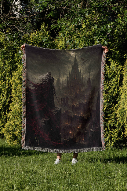A person is standing in a grassy area, holding up a large blanket that features a dark, ominous castle-like scene.