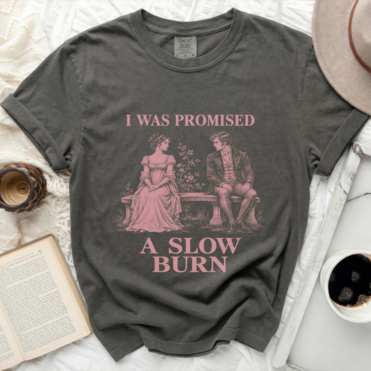 Charcoal t-shirt with pink graphic of a couple on a bench and text "I WAS PROMISED A SLOW BURN".