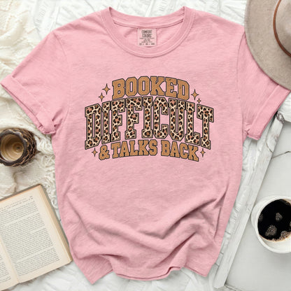 Pink t-shirt with leopard print text "Booked, Difficult, & Talks Back".