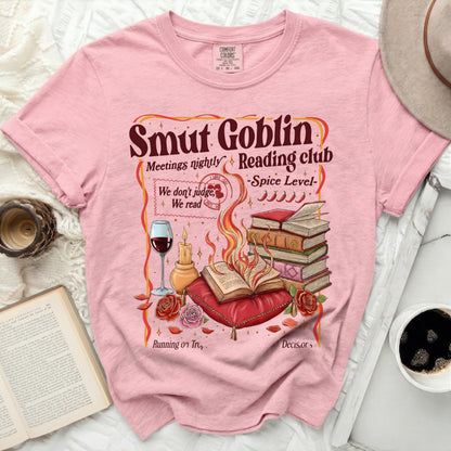 Pink t-shirt with "Smut Goblin Reading Club" graphic and book-themed illustration.