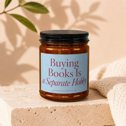 Amber candle with a light blue label that reads "Buying Books Is a Separate Hobby".