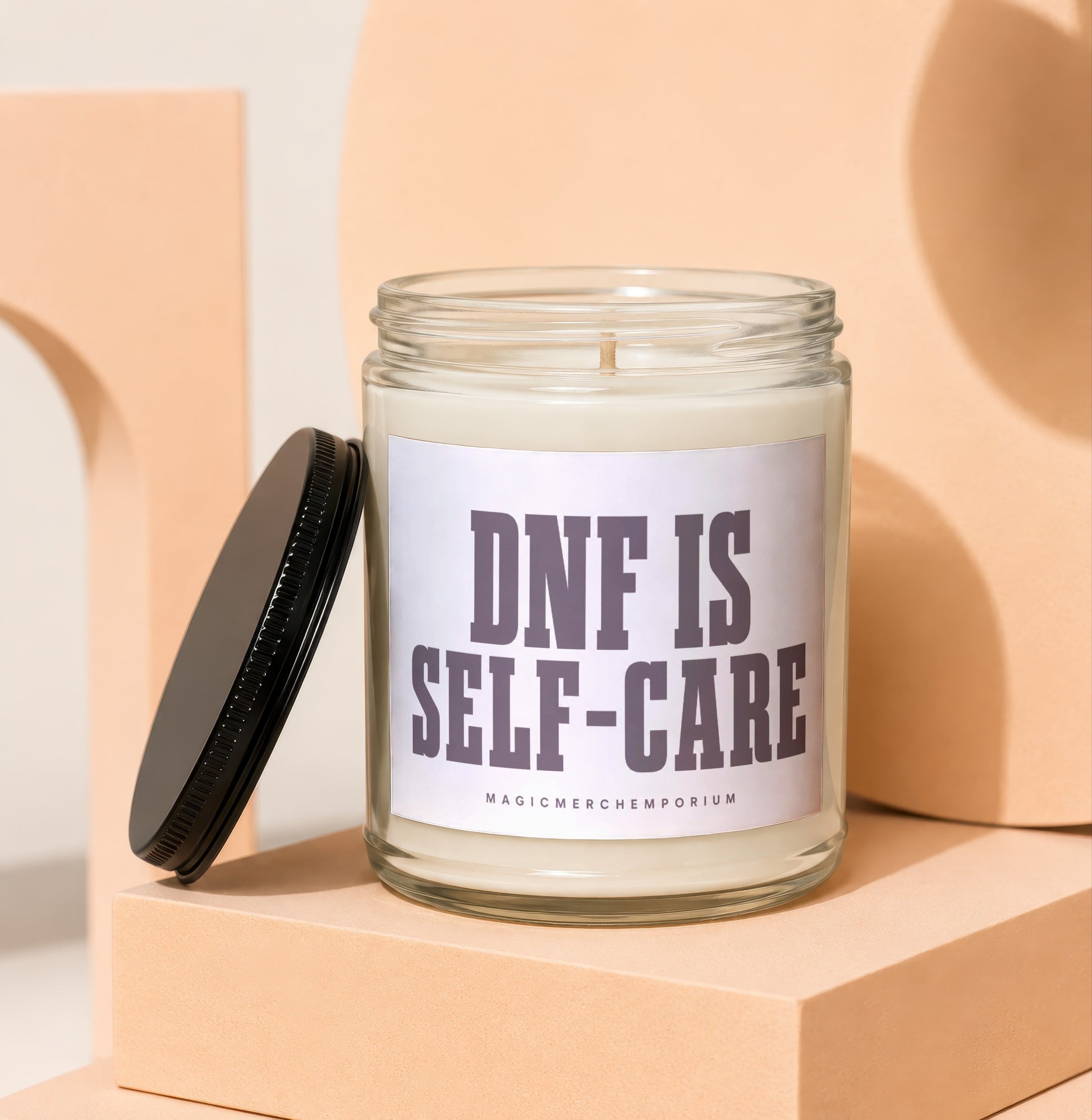 Clear jar candle with black lid and label reading "DNF IS SELF-CARE".