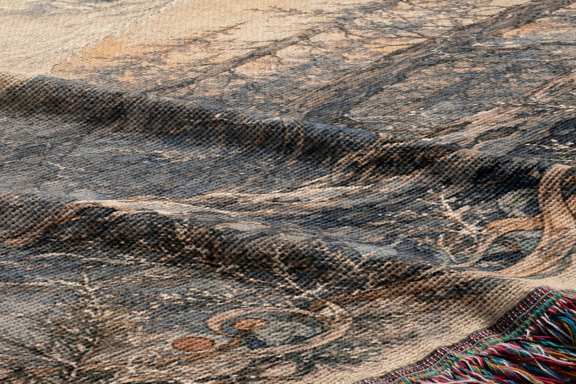 The image is a close-up of a textured fabric with a pattern of trees and foliage, including a tree branch and leaves. The fabric appears to be a woven or knitted material, with a dark and earthy color palette.
