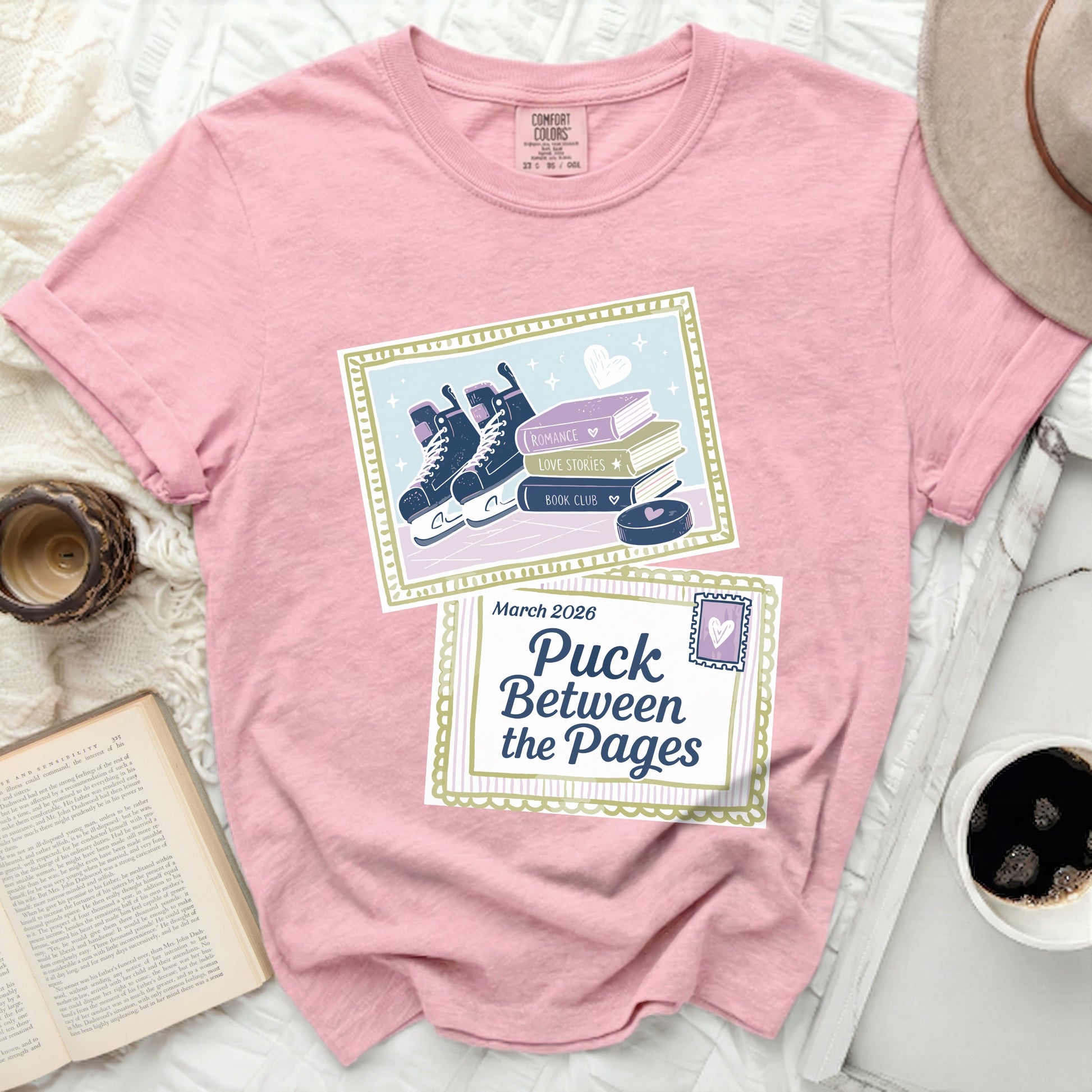 Pink t-shirt with roller skates, books, and "Puck Between the Pages" text.