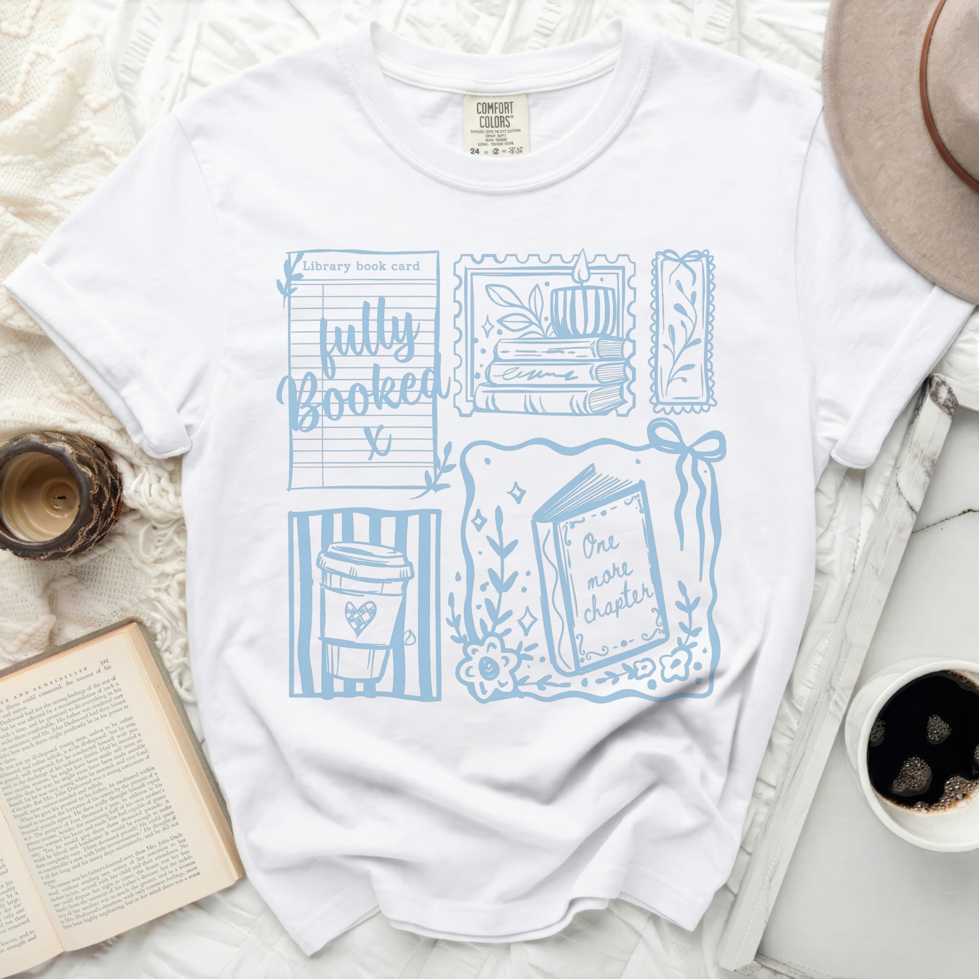 White t-shirt with light blue library card and book-themed graphic.