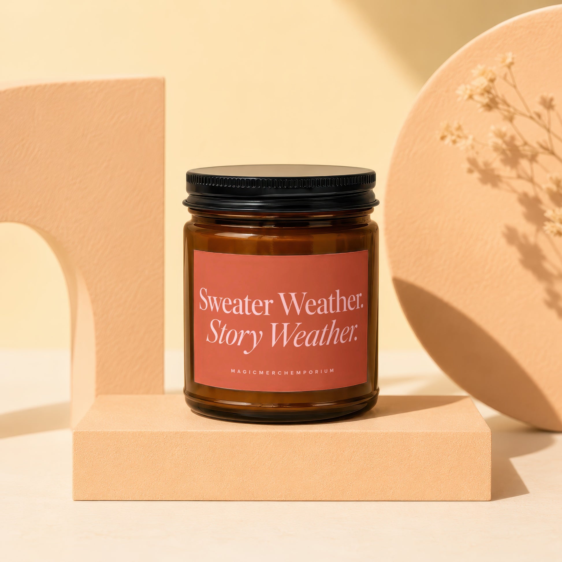 Candle with "Sweater Weather Story Weather" label on a pedestal.